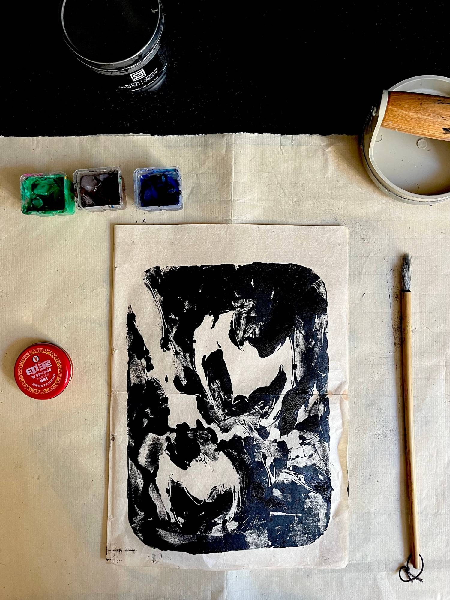 In the studio: a freshly pulled impression with ink, roller, chop paste and brush